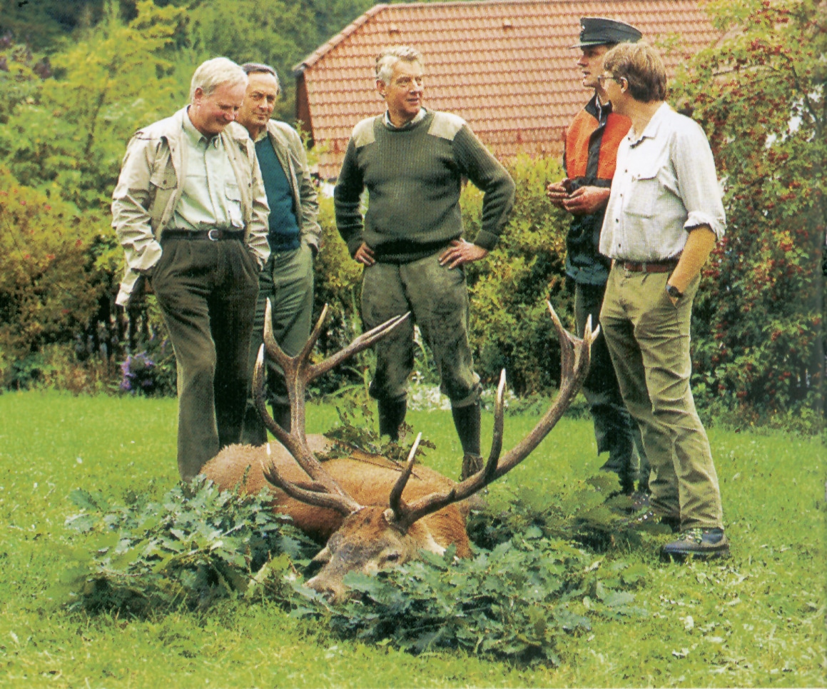 Personen an einem zur Strecke gelegten Hirsch